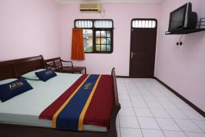 a bedroom with a bed and a television in a room at Hotel Danau Indah By ARBA in Cibuntu
