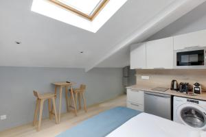 een kamer met een bed en een keuken met een wasmachine bij Charmant et central - Neuilly in Neuilly-sur-Seine +2 foto's