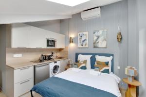 een kleine slaapkamer met een bed en een keuken bij Charmant et central - Neuilly in Neuilly-sur-Seine