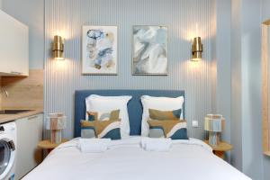 een slaapkamer met een groot bed met een blauw hoofdeinde bij Charmant et central - Neuilly in Neuilly-sur-Seine