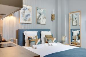 een slaapkamer met een bed met een blauw hoofdeinde en kussens bij Charmant et central - Neuilly in Neuilly-sur-Seine