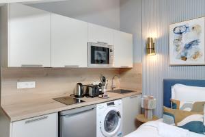 een keuken met een wasmachine en een wasmachine bij Charmant et central - Neuilly in Neuilly-sur-Seine