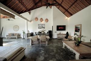 een woonkamer met een tafel en stoelen bij Indiana Kenanga Boutique Hotel & Spa in Nusa Lembongan