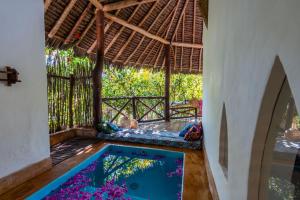 a room with a swimming pool in a house at SeVi Boutique Hotel in Matemwe