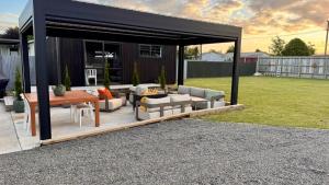 a screened in patio with furniture and a table at The Mango Shed in Mangakino