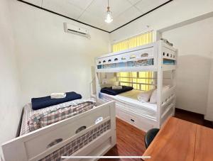 2 Etagenbetten in einem Zimmer mit einem Tisch in der Unterkunft Puri Sagan in Yogyakarta