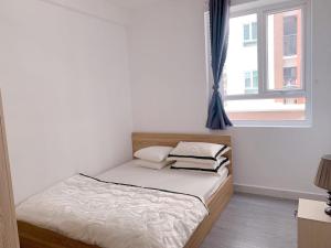 a small bed in a room with a window at HomeDubai in Kinh Dinh
