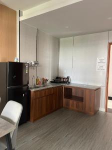 a kitchen with wooden cabinets and a black refrigerator at HomeDubai in Kinh Dinh
