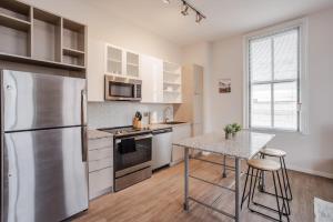 een keuken met een roestvrijstalen koelkast en een tafel bij CozySuites Sky Central #20 in Cincinnati +17 foto's