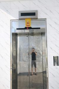 een man die in een glazen lift staat bij Tân Ty Mon Hotel in Ho Chi Minh-stad