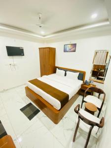 a bedroom with a large bed and a chair at Rama Grand Palace in Ayodhya