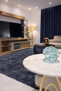 een woonkamer met een tv en een tafel bij Abu Rakan Apartment in Muscat