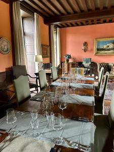 una sala da pranzo con un lungo tavolo e bicchieri da vino di Château de La Tour en Brenne a Rivarennes