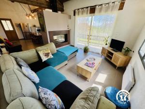 a living room with a blue couch and a tv at Nore & nature in Pradelles-Cabardès