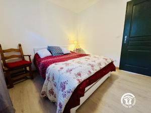 a bedroom with a bed with a red blanket and a chair at Nore & nature in Pradelles-Cabardès