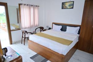 a bedroom with a bed and a table and a window at Rama Grand Palace in Ayodhya +43 photos