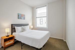 una camera da letto bianca con un letto e una finestra di TWO CozySuites Sky Central Rooftop Pool #29 a Cincinnati