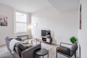 un soggiorno con un divano e un tavolo di TWO CozySuites Sky Central Rooftop Pool #29 a Cincinnati Altre 24 foto