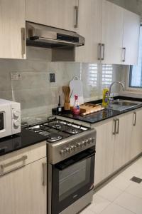 een keuken met een fornuis en een wastafel. bij Abu Rakan Apartment in Muscat
