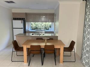 a kitchen with a wooden dining table and chairs at Your Leafy Ivanhoe Retreat in Melbourne