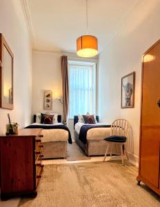 een slaapkamer met twee bedden en een raam bij Dairsie Sea View in Rothesay