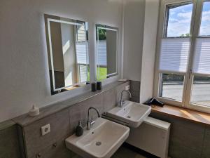 a bathroom with two sinks and two windows at Ferien im Denkmal in Sundern +19 photos