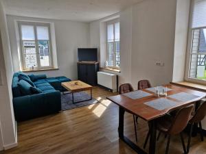 a living room with a blue couch and a table at Ferien im Denkmal in Sundern