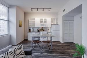 a kitchen with a table and chairs in a room at TWO CozySuites Sky Central Rooftop Pool #30 in Cincinnati