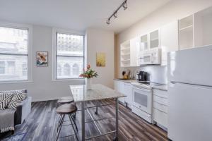 a kitchen with white cabinets and a counter top at TWO CozySuites Sky Central Rooftop Pool #30 in Cincinnati