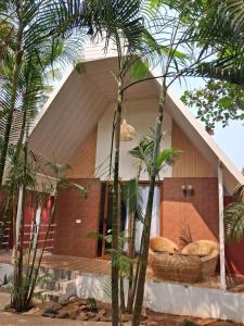 a house with palm trees in front of it at Sea Shades Cottages I Private Jacuzzi in Palolem