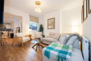 a living room with a couch and a table at Goulder House- Close To Motorway & CO-OP Live in Manchester