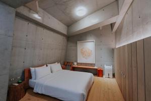 una camera con un letto bianco e una mappa sul muro di Mao House a Tainan Altre 51 foto