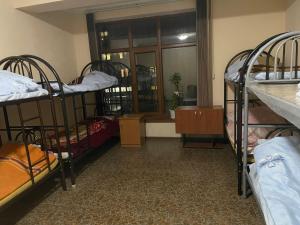 a room with three bunk beds and a window at Anissa in Shymkent