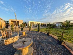 a park with a bench and some trees and buildings at LeLaNa Farmstay Camping in Pak Chong