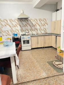 a kitchen with a stove and a counter top at Anissa in Shymkent