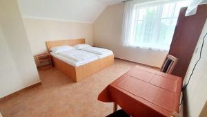a small bedroom with a bed and a table at Penzion rodina in Chornice