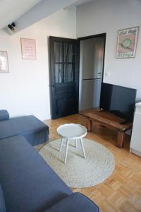 un soggiorno con un divano e un tavolo di Appartement confort tout équipé a Montrevel-en-Bresse