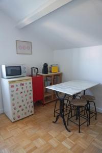 una piccola cucina con un tavolo e un microonde di Appartement confort tout équipé a Montrevel-en-Bresse