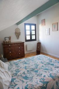 una camera da letto con un letto, un comò e una finestra di Appartement confort tout équipé a Montrevel-en-Bresse