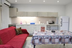 a kitchen with a red couch and a table in a kitchen at EmilyApartments 1 in Chrysoupolis