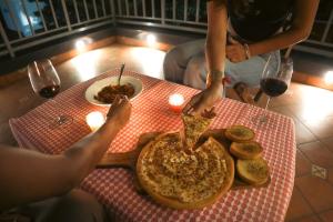 a person eating a slice of pizza at a table at Moti Villa in Jāmb