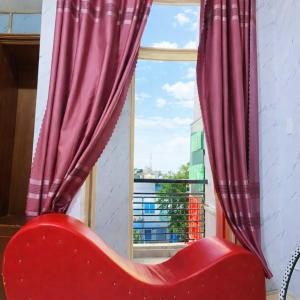 a red chair sitting in front of a window at Duy Khang 1 Hotel in Ho Chi Minh City