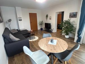 un soggiorno con un divano e un tavolo di Ferienwohnung Schönheit a Gönnern