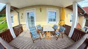 a patio with a table and chairs and a umbrella at Romy in Gundersdorf