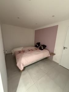 a bedroom with a bed with two pillows on it at Murmure de rose in Rosnoën