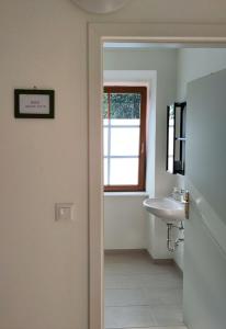 a white bathroom with a sink and a window at Wohnen im Meierhof in Hohenwarth +53 photos