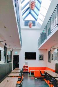 een restaurant met tafels en stoelen en een dakraam bij Dancenter Hotel Jomfru Ane in Aalborg