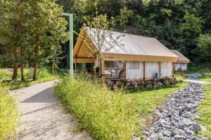 a building with a tin roof next to a gravel road at Landal Namur Nature in Gesves