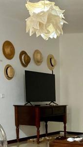 een televisie op een tafel in een woonkamer met een kroonluchter bij Casa de Azzancha in Azinhaga +55 foto's