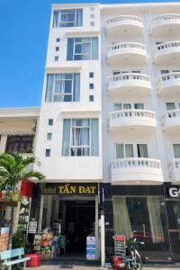 een hoog wit gebouw met een beige dartbord erop bij Tấn Đạt Hotel Quy Nhơn in Quy Nhon